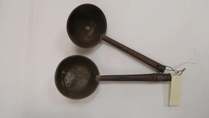 Two vintage cooking ladles hanging on a white wall. — civilrightsmuseum.org
